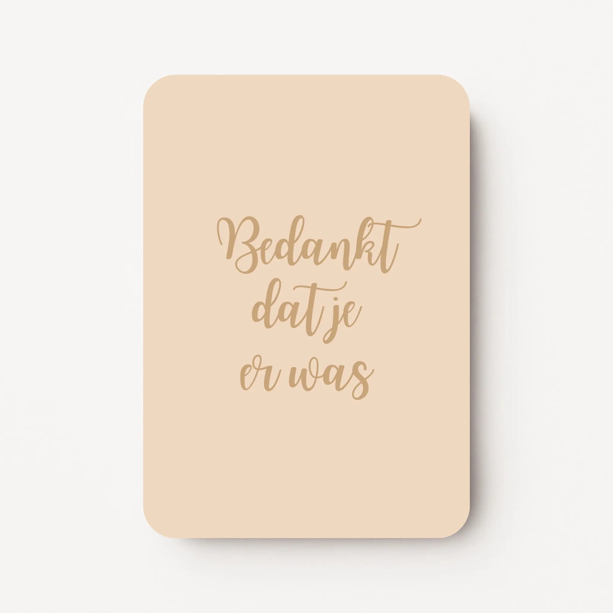 Staande bedankkaart met tekst ‘Bedankt dat je er was’ in sierlijke letters, goudbruine tekst op beige achtergrond, flatlay op witte ondergrond.