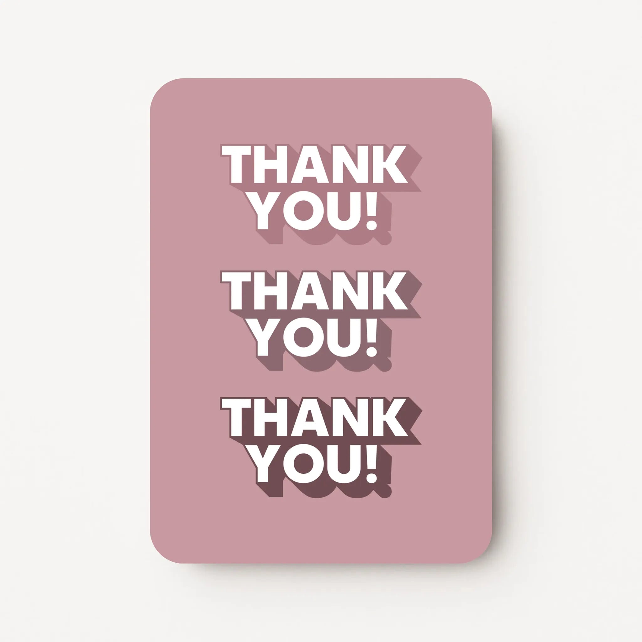 Staande bedankkaart met tekst ‘THANK YOU’ driemaal herhaald, witte letters op oudroze achtergrond, flatlay op witte ondergrond.