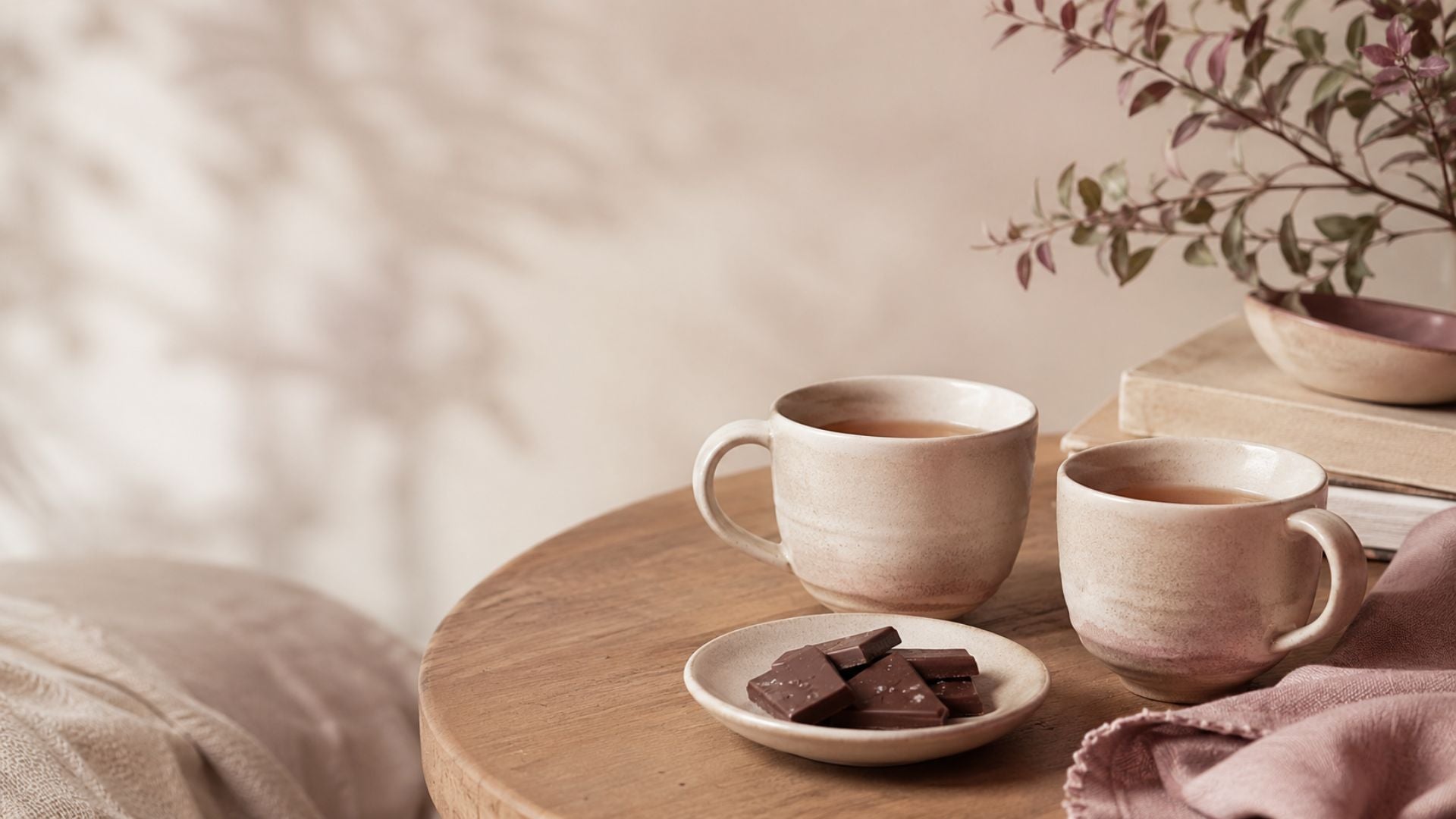 Warme vriendschapssfeer met twee kopjes thee, chocolade en zachte braambes accenten.