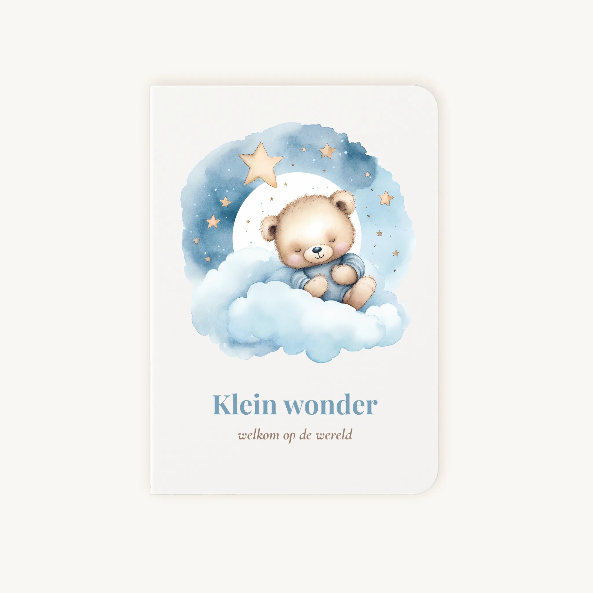Staande dubbelgevouwen felicitatiekaart geboorte jongen met zachte pastelkleuren, lieve beer op wolk onder sterrenhemel, met de tekst "Klein wonder - welkom op de wereld", flatlay op lichte achtergrond.