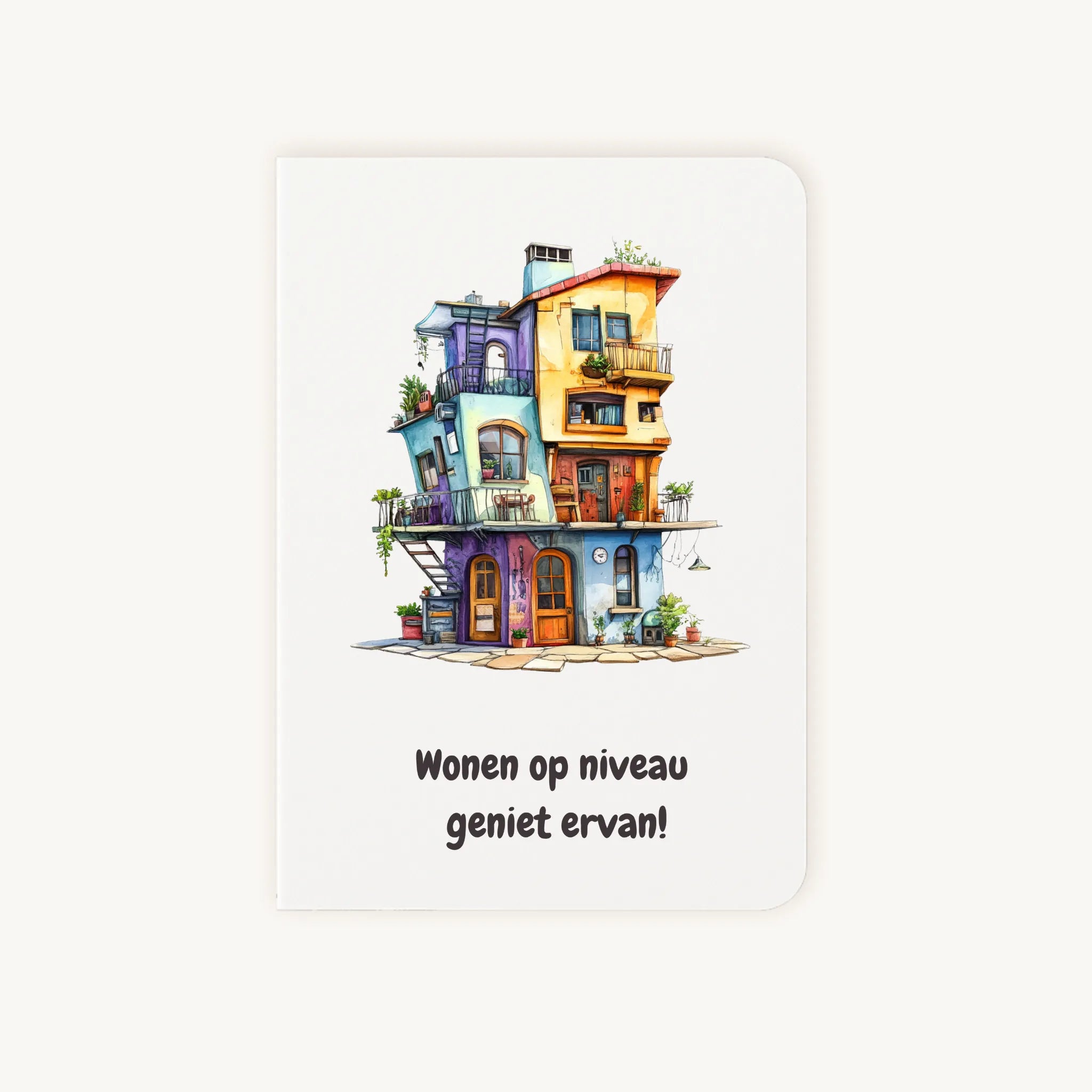 Staande dubbelgevouwen kaart nieuwe woning met afgeronde hoekjes en speelse aquarelillustratie van een fantasierijk huis, met de tekst Wonen op niveau geniet ervan, flatlay op lichte achtergrond.