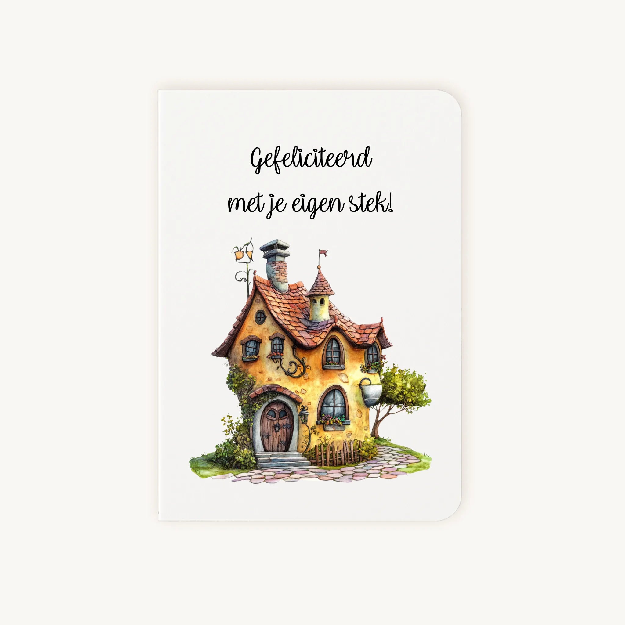 Staande dubbelgevouwen kaart nieuwe woning met afgeronde hoekjes en zachte aquarelillustratie van een sprookjesachtig huisje, met de tekst Gefeliciteerd met je eigen stek, flatlay op lichte achtergrond.