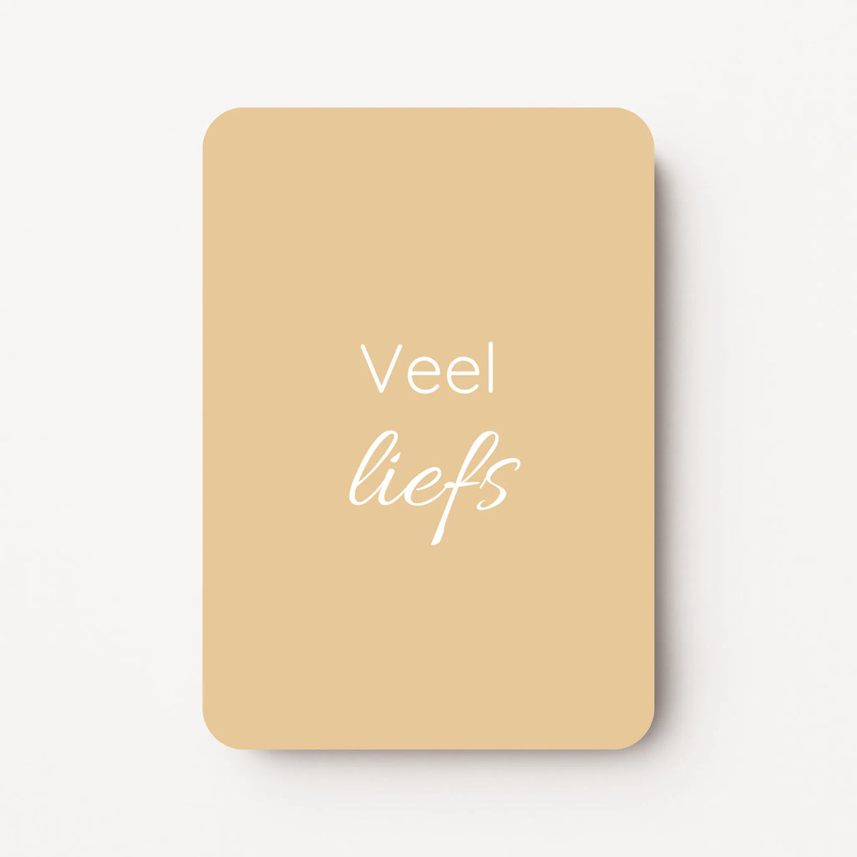 Staande minikaart met witte tekst "Veel liefs", minimalistisch ontwerp op een zachte gele achtergrond.