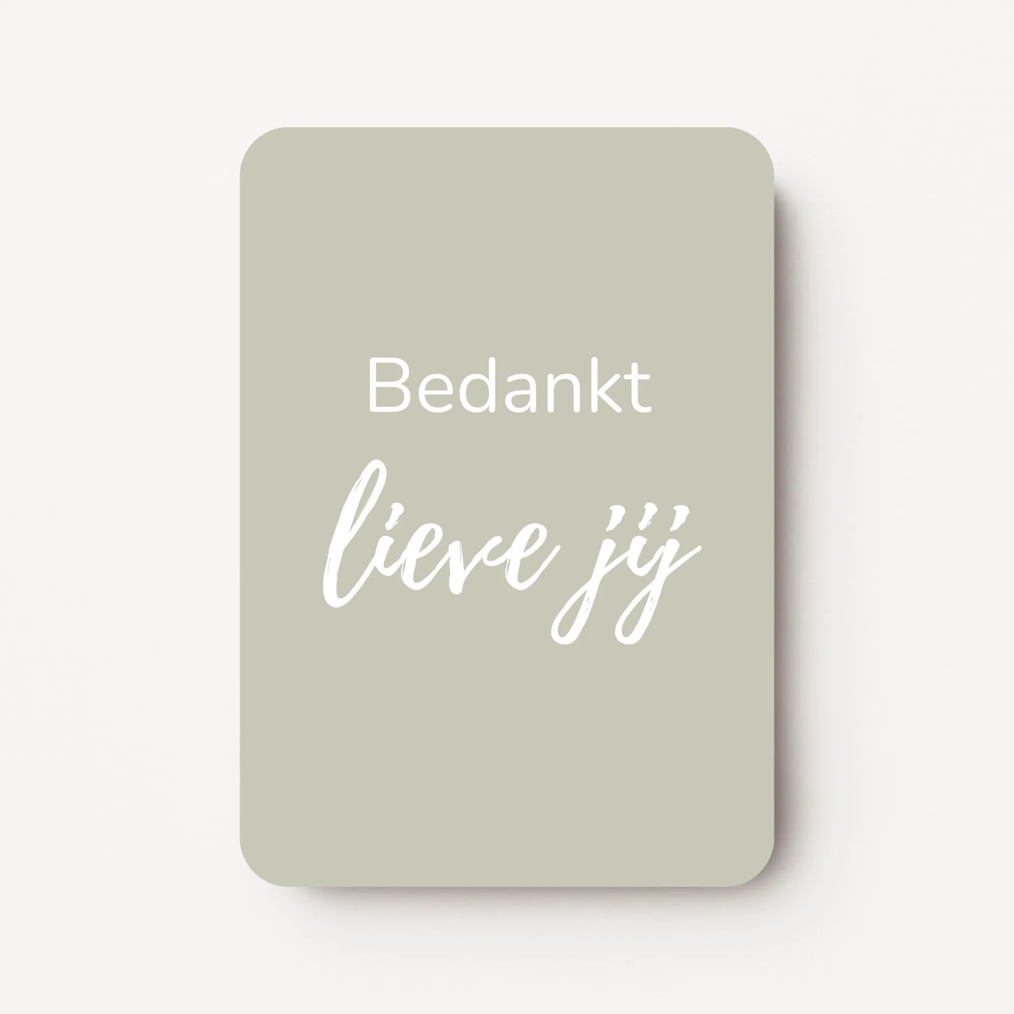 Staand minikaartje met witte tekst ‘Bedankt lieve jij’ op licht taupe-grijze achtergrond, minimalistisch ontwerp, flatlay op witte ondergrond.