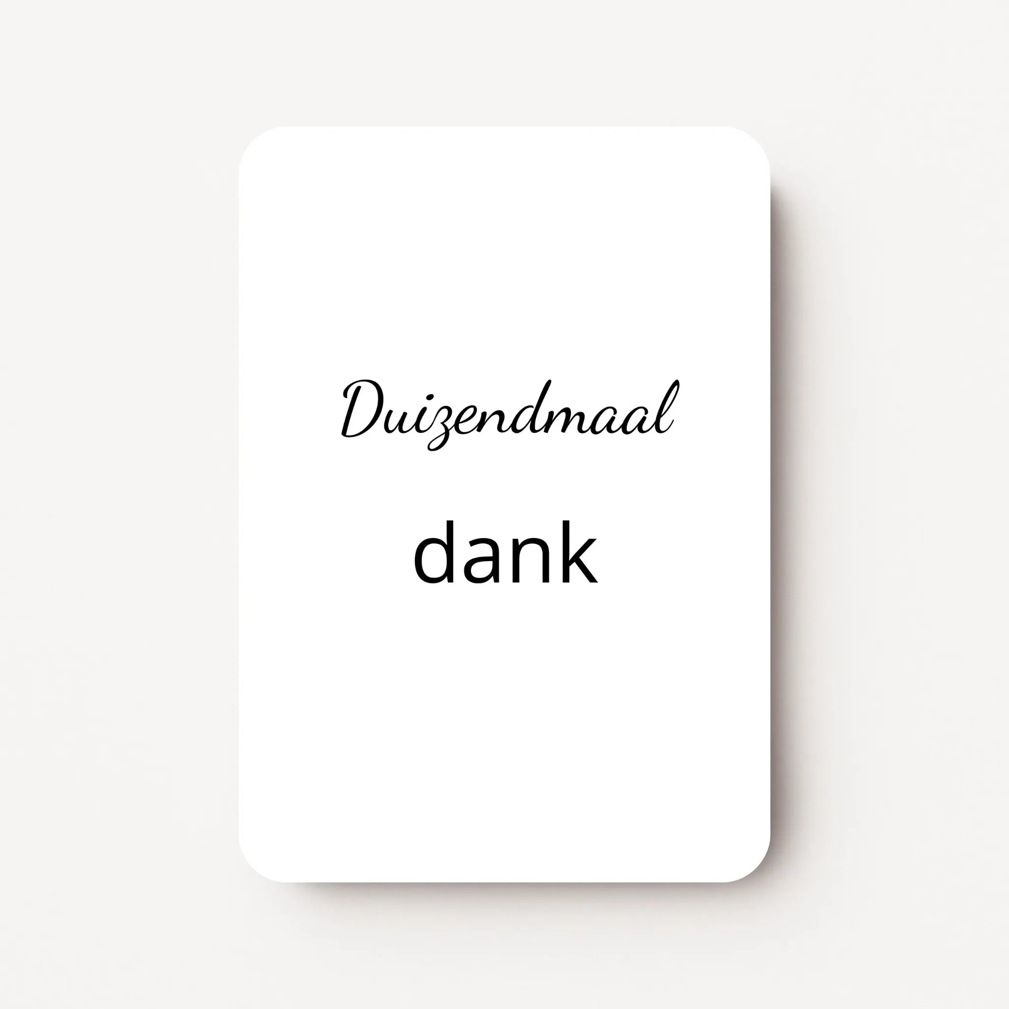 Staand minikaartje met tekst ‘Duizendmaal dank’ in zwarte letters, minimalistisch ontwerp op witte achtergrond, flatlay op witte ondergrond.