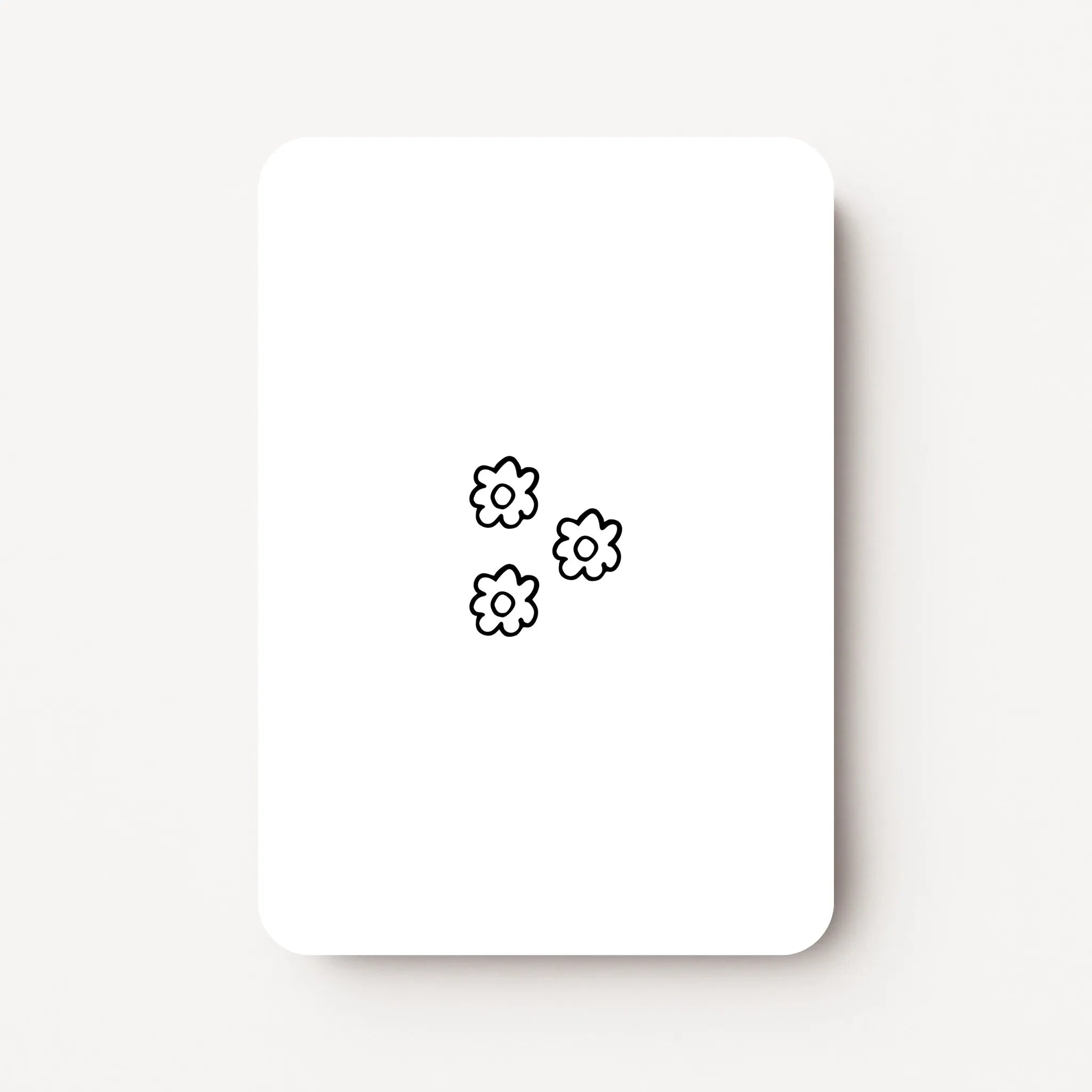 Staand minikaartje met drie kleine lineart-bloemetjes in zwarte lijntekening, minimalistisch ontwerp op witte achtergrond, flatlay op witte ondergrond.