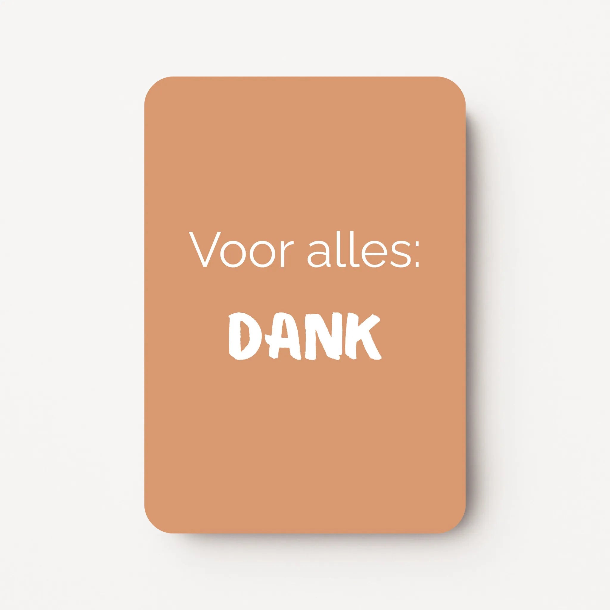 Staand minikaartje met witte tekst ‘Voor alles: DANK’ op warme caramelkleurige achtergrond, minimalistisch ontwerp, flatlay op witte ondergrond.