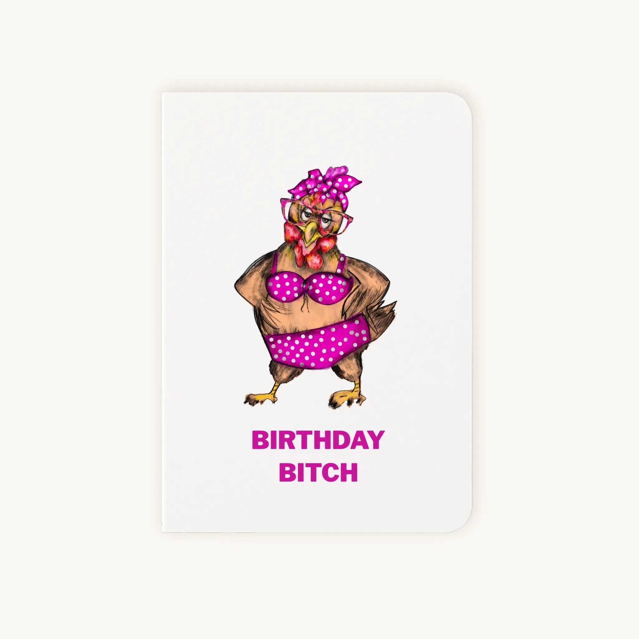 Staande dubbelgevouwen verjaardagskaart met zelfverzekerde kip in knalroze bikini met stippen en strik, met tekst Birthday bitch, flatlay op lichte achtergrond.