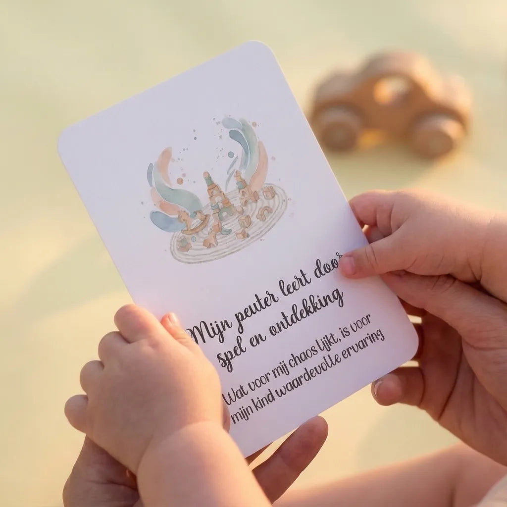 Ouder en peuter handen samen met affirmatiekaart en speelgoedautootje, lifestyle foto vol verbinding en ontdekking