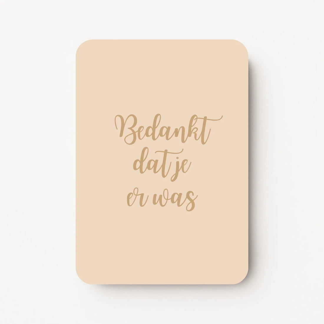 Staande bedankkaart met tekst ‘Bedankt dat je er was’ in sierlijke letters, goudbruine tekst op beige achtergrond, flatlay op witte ondergrond.