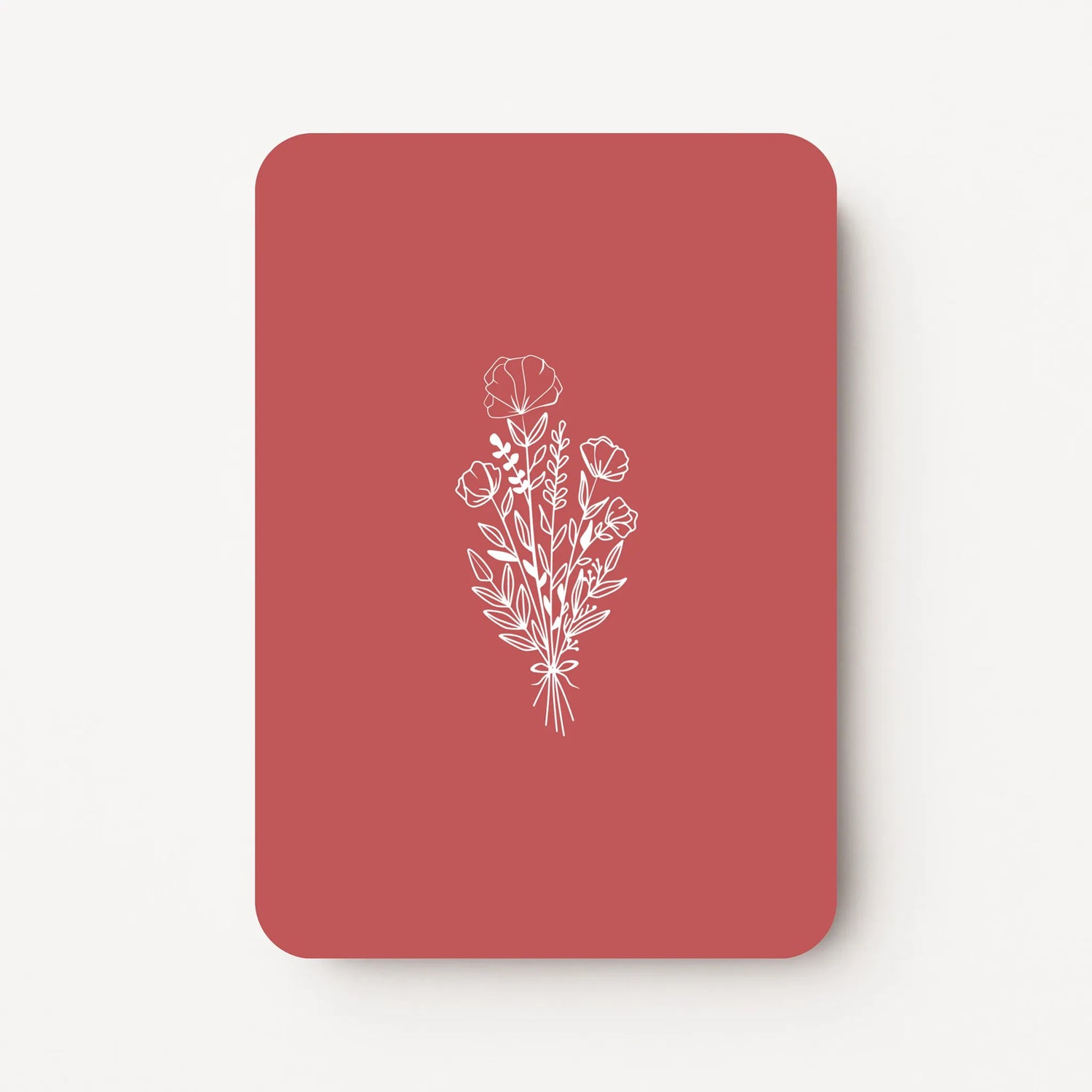 Staande bedankkaart met witte bloemen line art op dieprode achtergrond, flatlay op witte ondergrond.