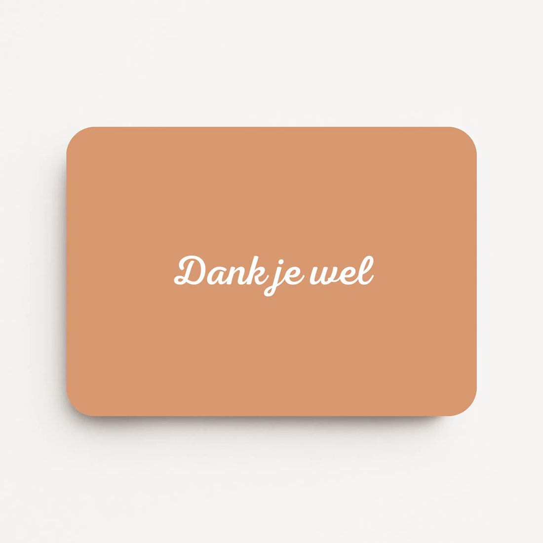 Liggende bedankkaart met tekst ‘Dank je wel’, witte letters op zandkleurige achtergrond, flatlay op witte ondergrond.