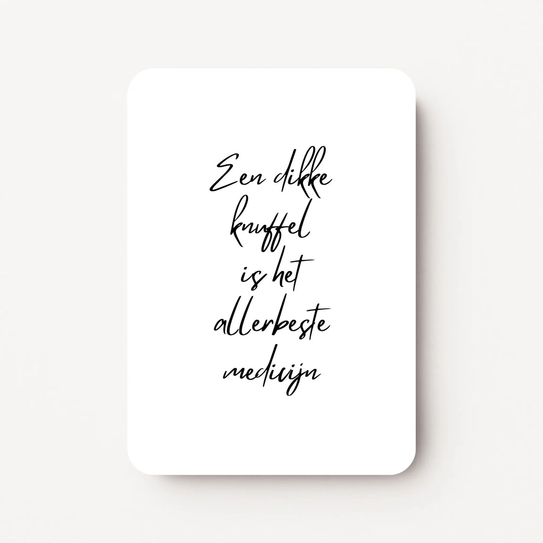 Staande beterschapskaart met zwarte tekst ‘Een dikke knuffel is het allerbeste medicijn’ op witte achtergrond, minimalistisch ontwerp, flatlay op witte ondergrond.