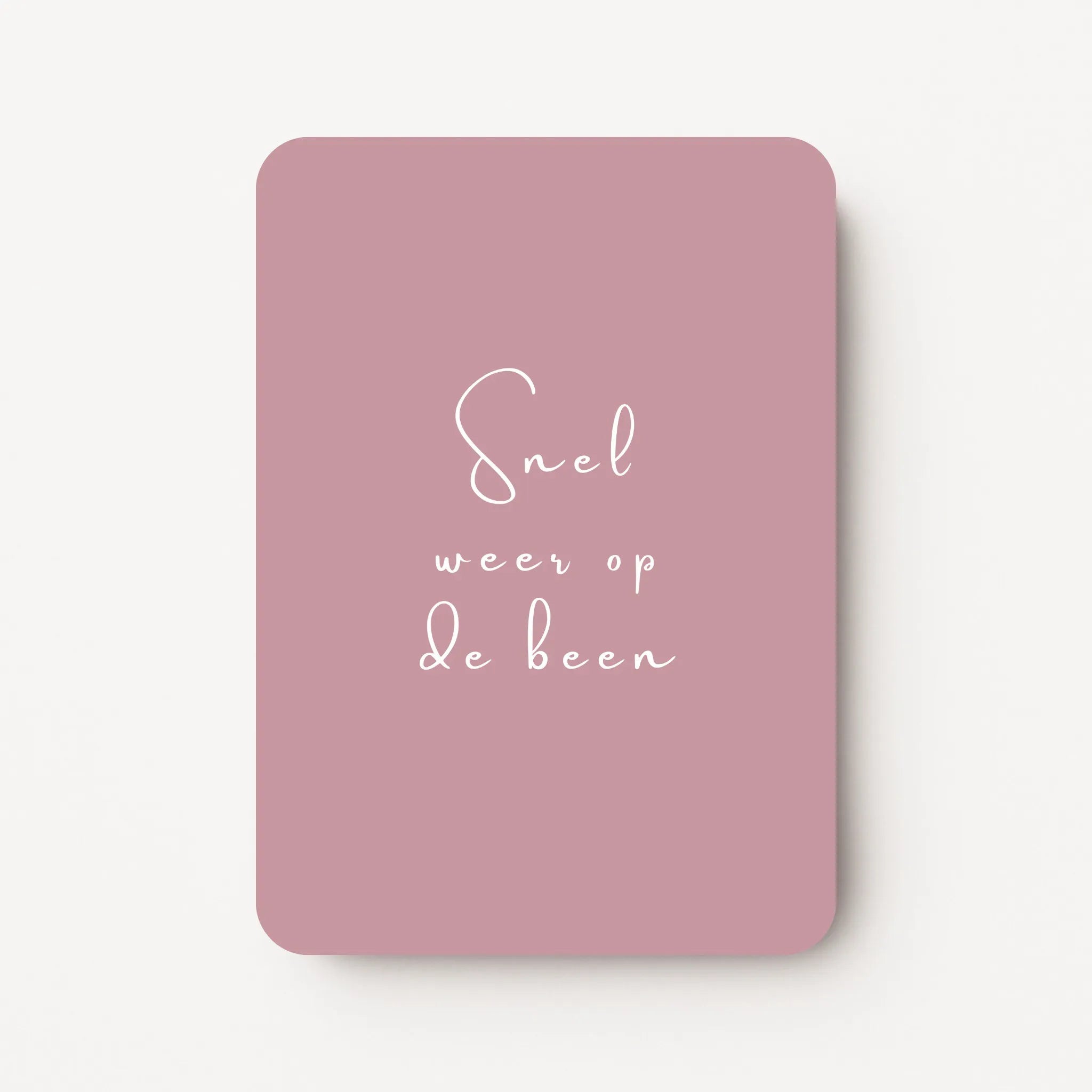 Staande beterschapskaart met witte tekst ‘Snel weer op de been’ op een zachte oudroze achtergrond, flatlay op witte ondergrond.