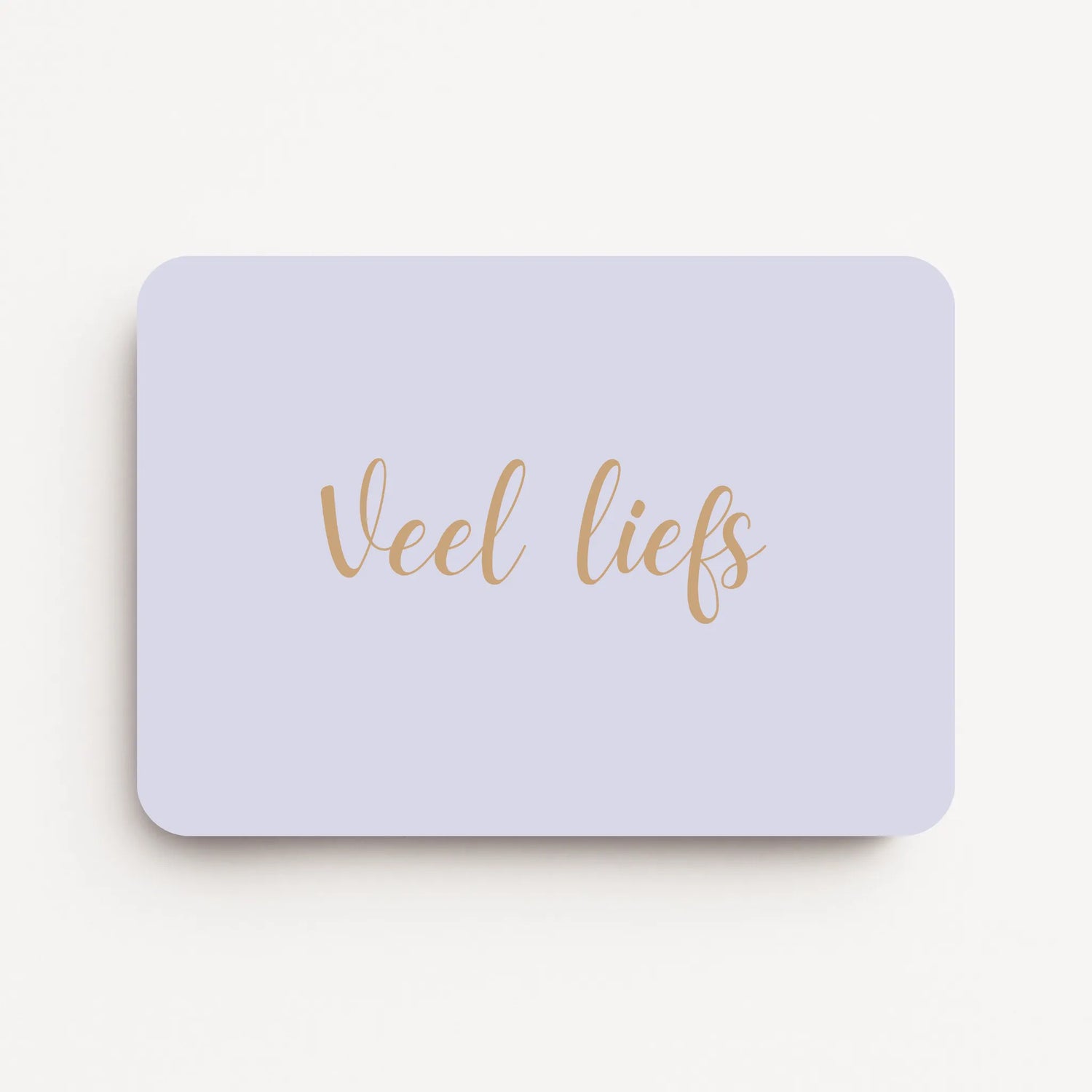 Liggende beterschapskaart met zachte lavendelgrijze achtergrond en tekst in warme zandtint ‘Veel liefs’, flatlay op witte ondergrond.