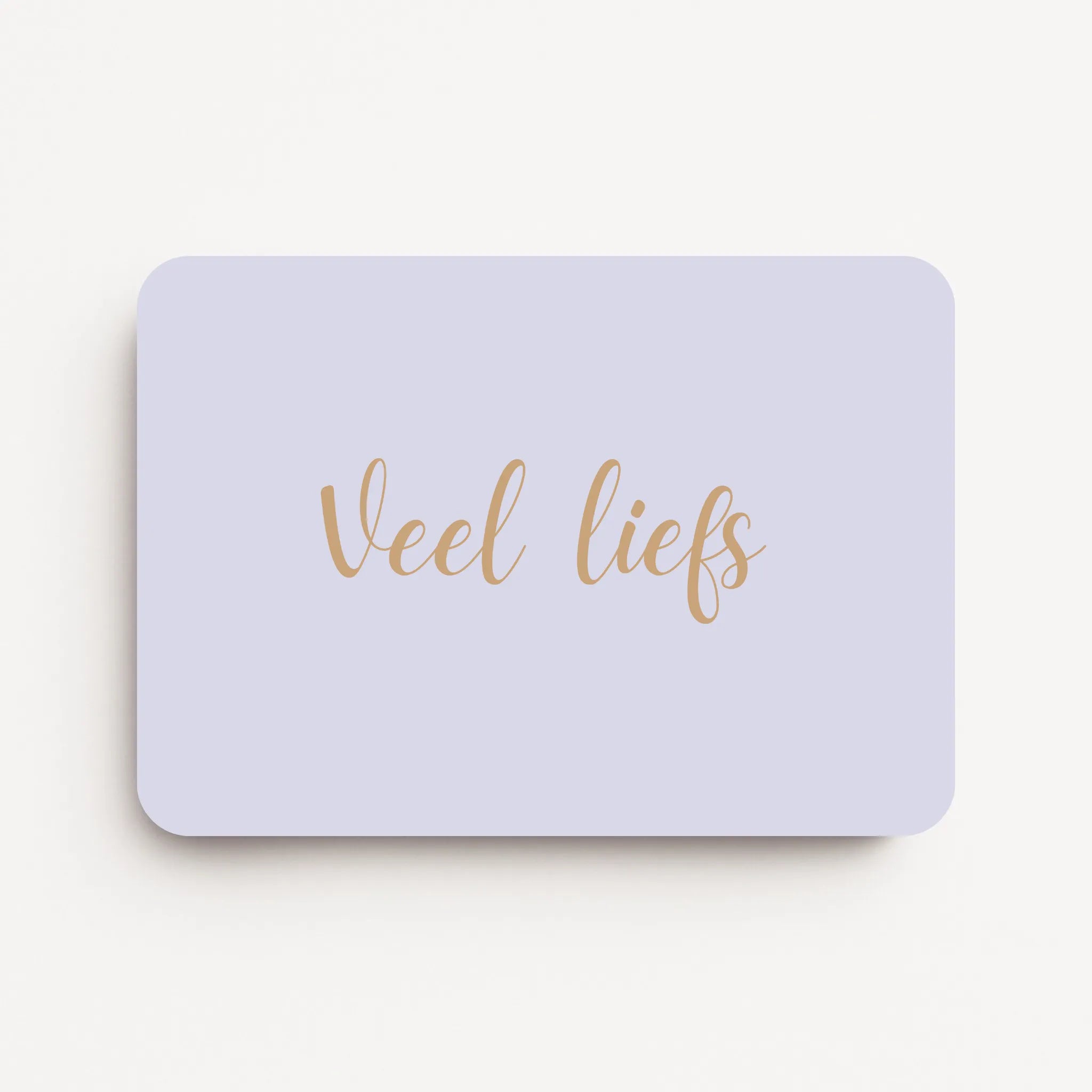 Liggende beterschapskaart met zachte lavendelgrijze achtergrond en tekst in warme zandtint ‘Veel liefs’, flatlay op witte ondergrond.
