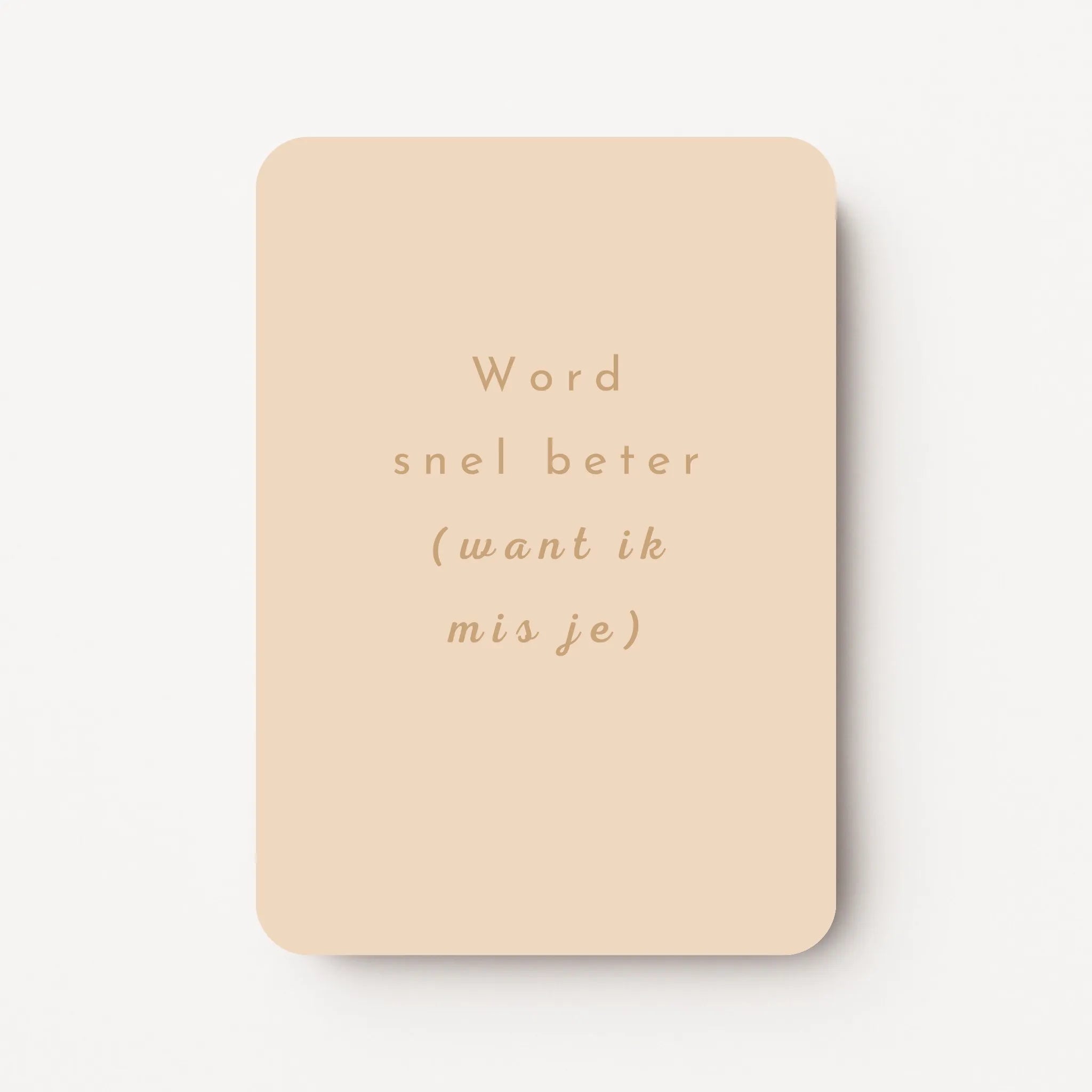 Staande beterschapskaart met licht perzikkleurige achtergrond en tekst in warme zandtint ‘Word snel beter (want ik mis je)’, flatlay op witte ondergrond.