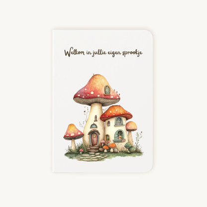 Staande dubbelgevouwen felicitatiekaart nieuwe woning met afgeronde hoekjes en aquarelillustratie van een schattig paddenstoelenhuis, met de tekst Welkom in jullie eigen sprookje, flatlay op lichte achtergrond.