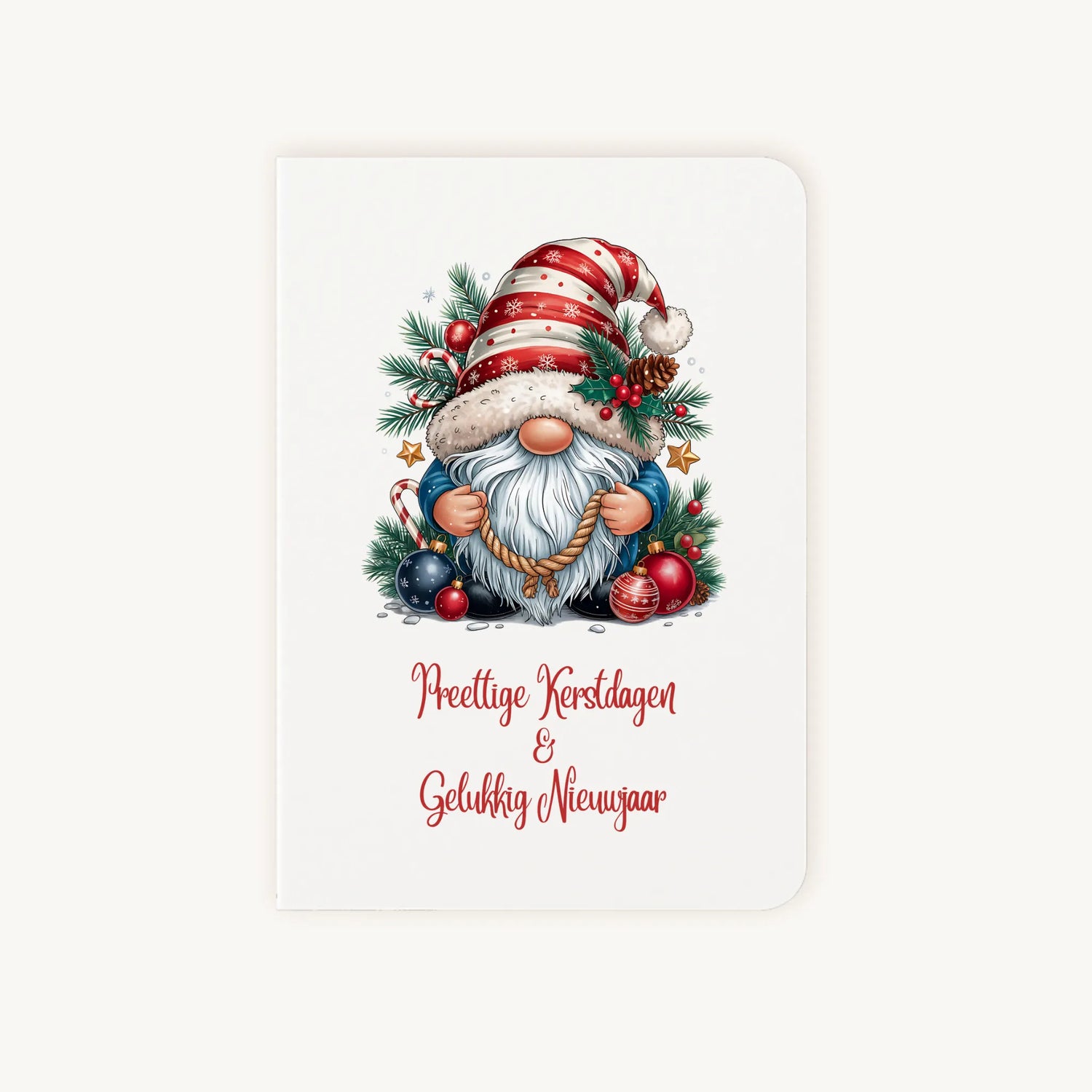 Staande dubbelgevouwen kerstkaart met aquarel kerstkabouter met rood-wit gestreepte muts en sierlijke tekst ‘Prettige Kerstdagen &amp; Gelukkig Nieuwjaar’, flatlay op lichte achtergrond.
