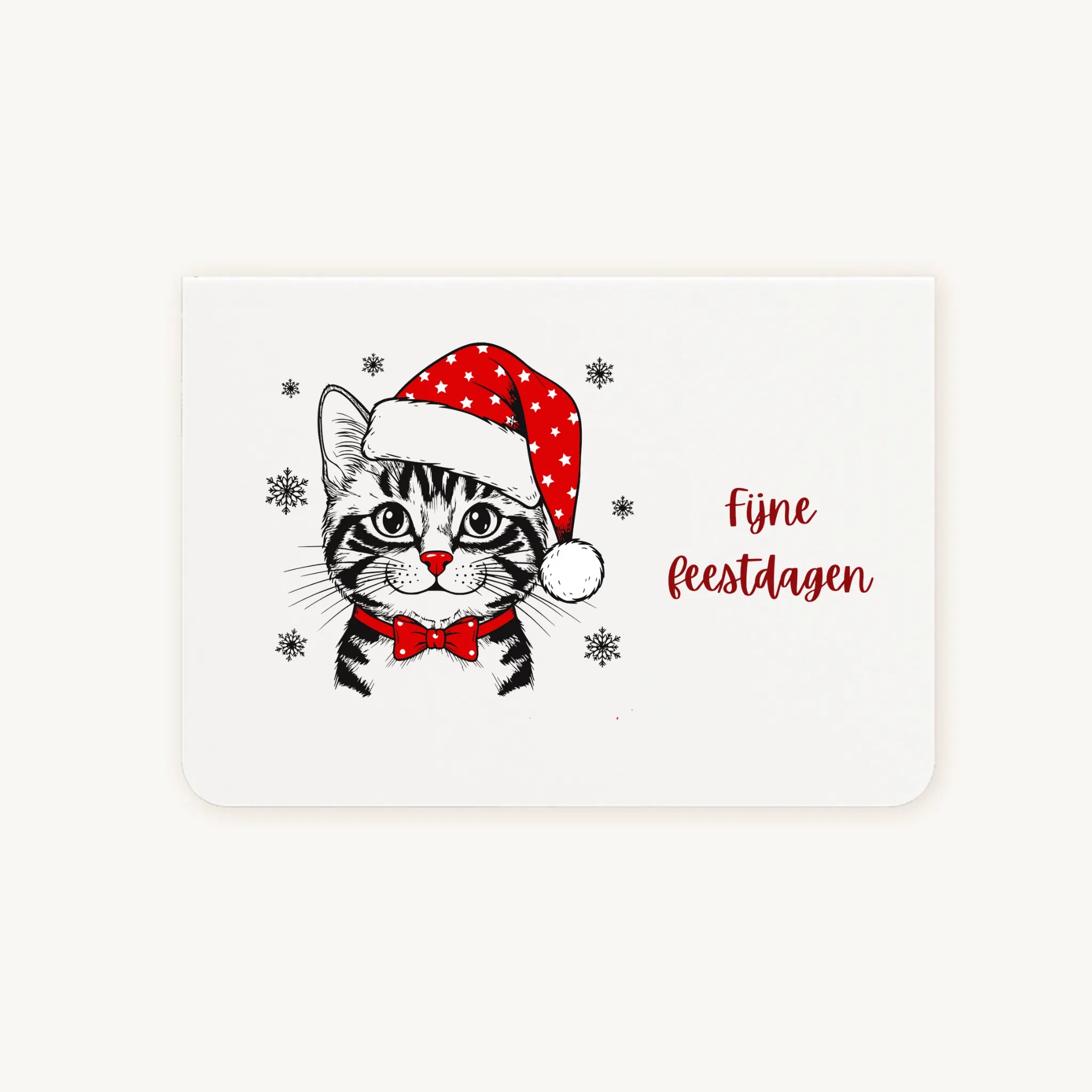 Liggende dubbelgevouwen kerstkaart met schattige zwart-witte kat met rode kerstmuts en vlinderdas in aquarel, sierlijke tekst ‘Fijne feestdagen’, flatlay op lichte achtergrond.