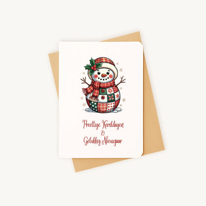 Staande kerstkaart met patchwork sneeuwpop in aquarelstijl op een kraftenvelop.