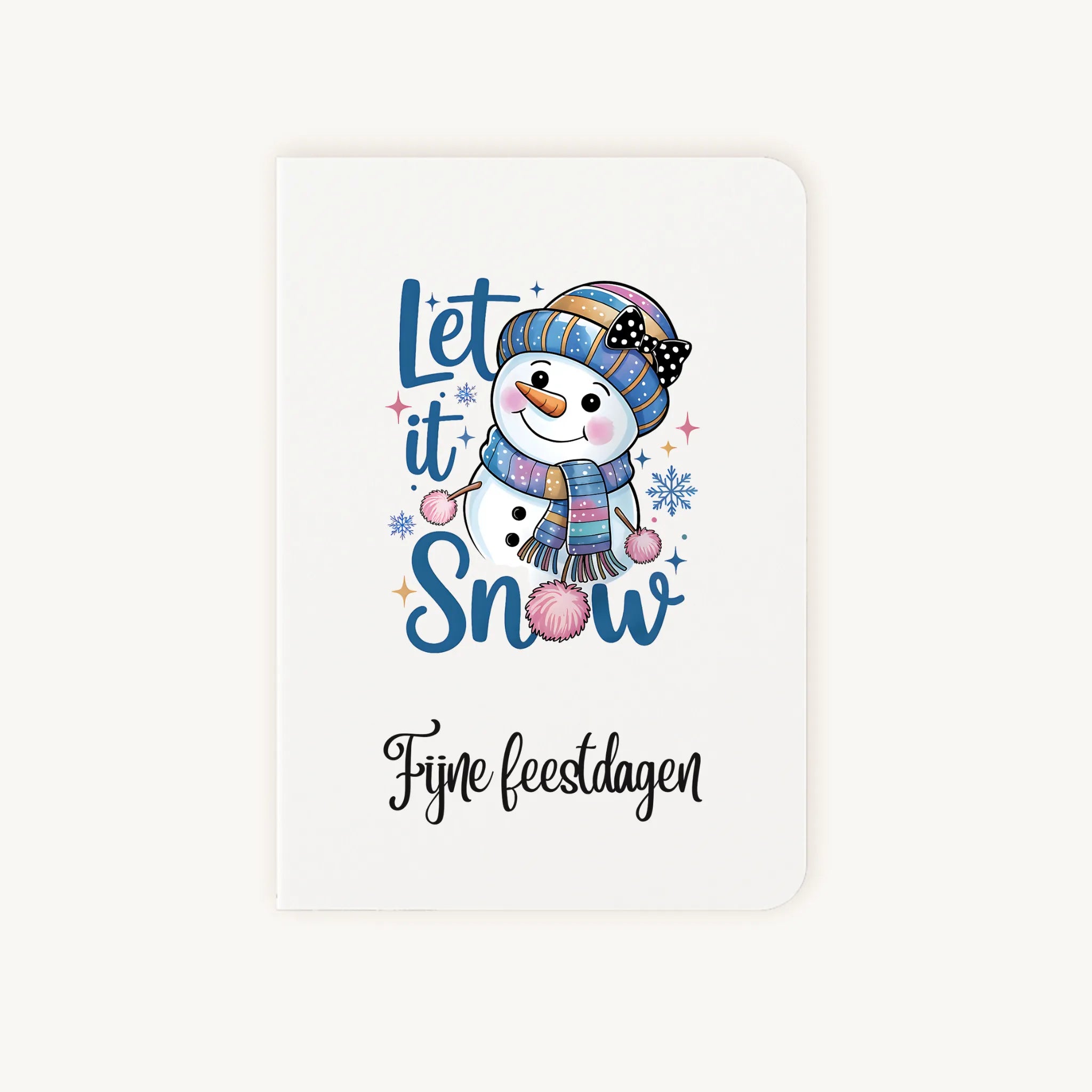 Staande dubbelgevouwen kerstkaart met vrolijke watercolor sneeuwpop met kleurrijke muts en sjaal en sierlijke tekst ‘Fijne feestdagen’, flatlay op lichte achtergrond.