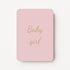 Staande minikaart met goudbeige tekst "Baby girl", minimalistisch ontwerp op een zachte warmgrijze achtergrond met een roze detail.