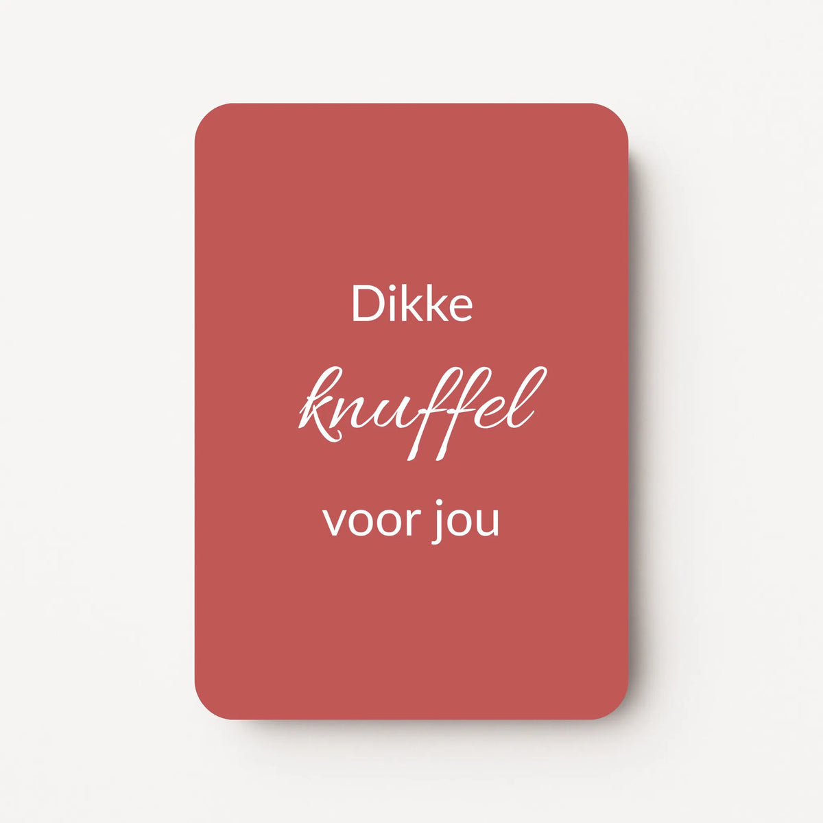 Staande minikaart met witte tekst "Dikke knuffel voor jou", minimalistisch ontwerp op een warme bordeauxrode achtergrond.