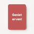 Staande minikaart met witte tekst "Geniet ervan!", minimalistisch ontwerp op een warme roodroze achtergrond.