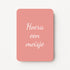 Staande minikaart met witte tekst "Hoera een meisje", minimalistisch ontwerp op een warme oudroze achtergrond.