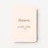 Staande minikaart met goudbeige tekst "Hoera voor jou", minimalistisch ontwerp op een zachte roomkleurige achtergrond.