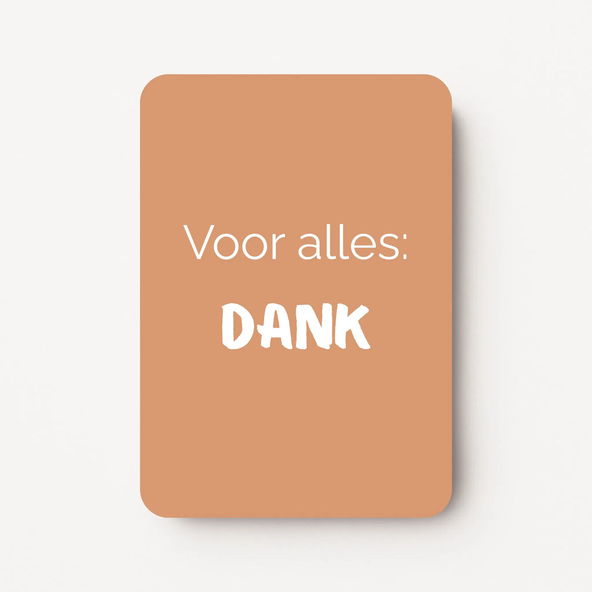 Staande minikaart met witte tekst "Voor alles: DANK", minimalistisch ontwerp op een warme karamelkleurige achtergrond.