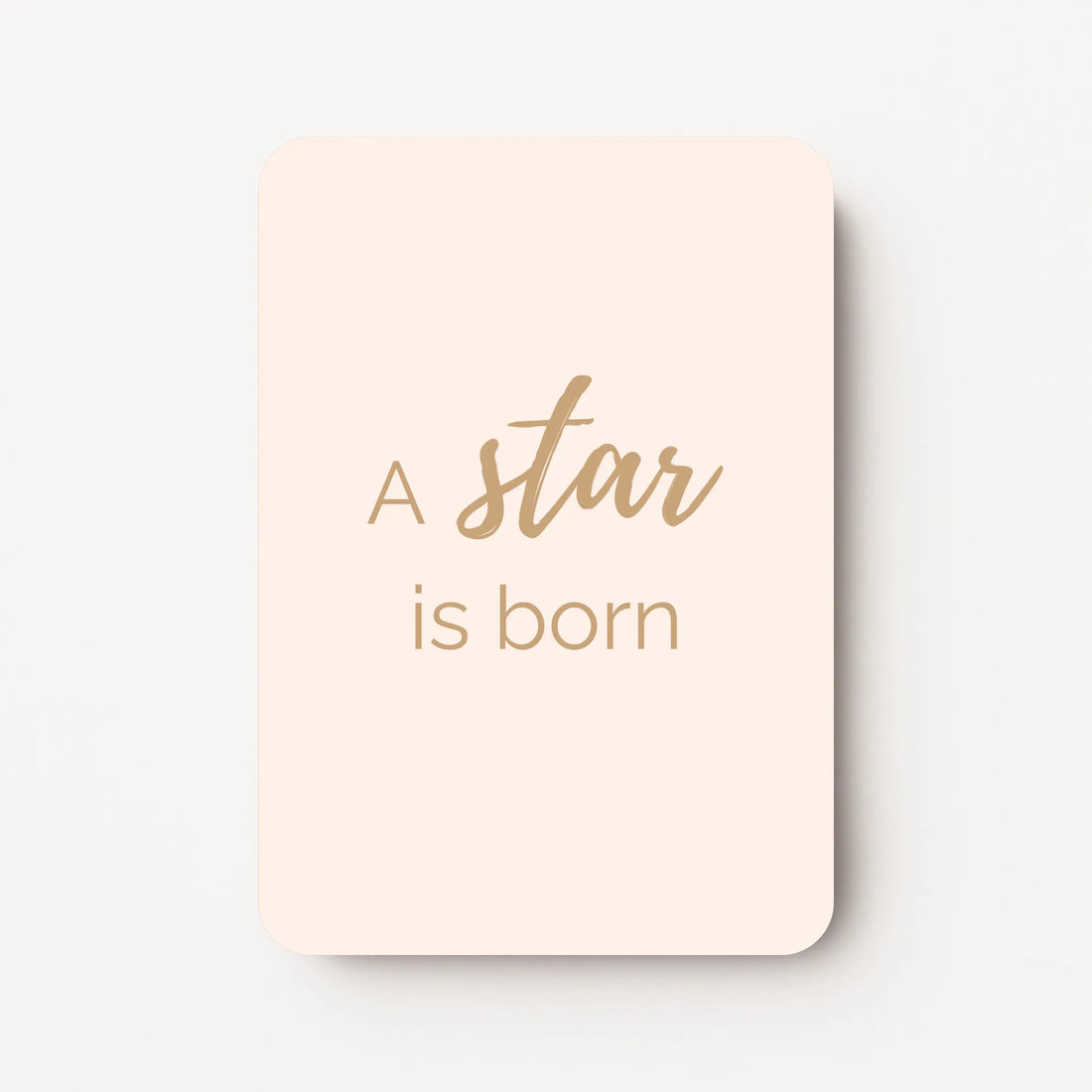 Staand minikaartje met tekst ‘A star is born’ in goudbeige letters, minimalistisch ontwerp op zachte perzik-witte achtergrond, flatlay op witte ondergrond.