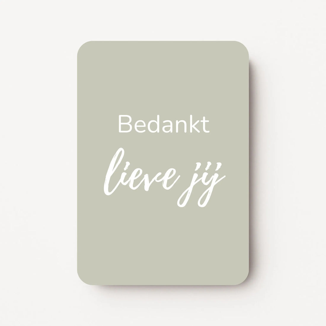Staand minikaartje met witte tekst ‘Bedankt lieve jij’ op licht taupe-grijze achtergrond, minimalistisch ontwerp, flatlay op witte ondergrond.