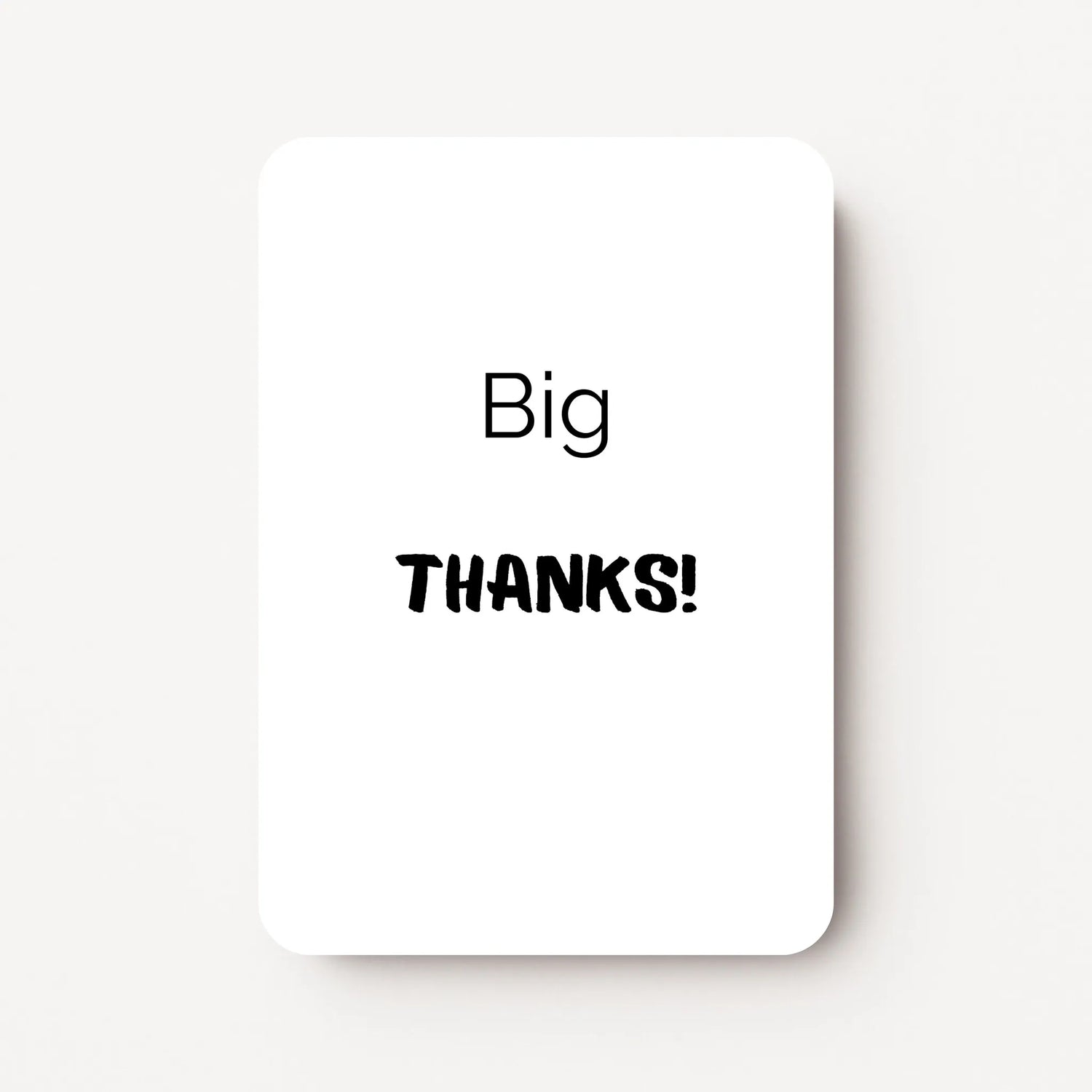 Staand minikaartje met tekst ‘Big THANKS’ in zwarte letters, minimalistisch ontwerp op witte achtergrond, flatlay op witte ondergrond.