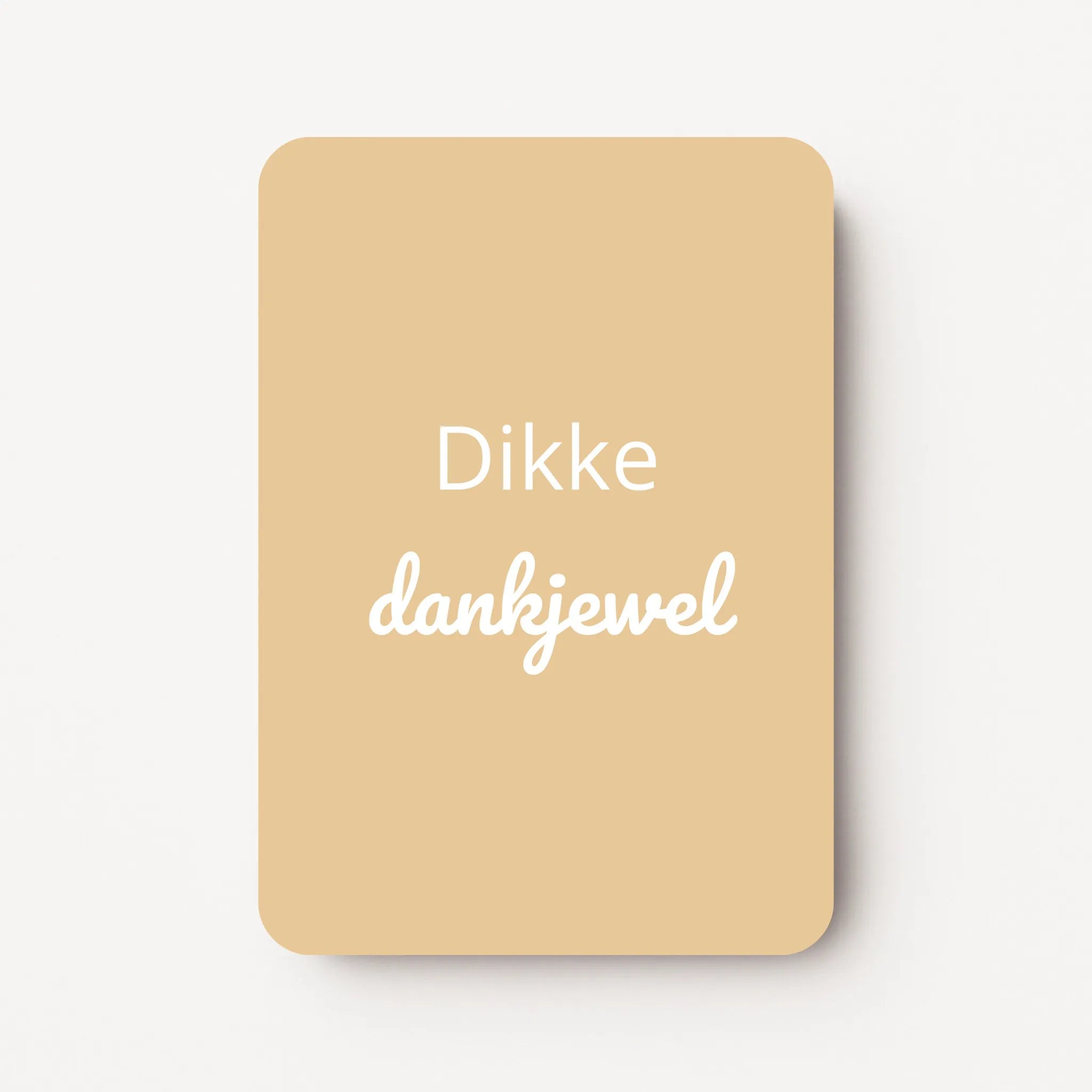 Staand minikaartje met witte tekst ‘Dikke dankjewel’ op zachte geel-beige achtergrond, minimalistisch ontwerp, flatlay op witte ondergrond.