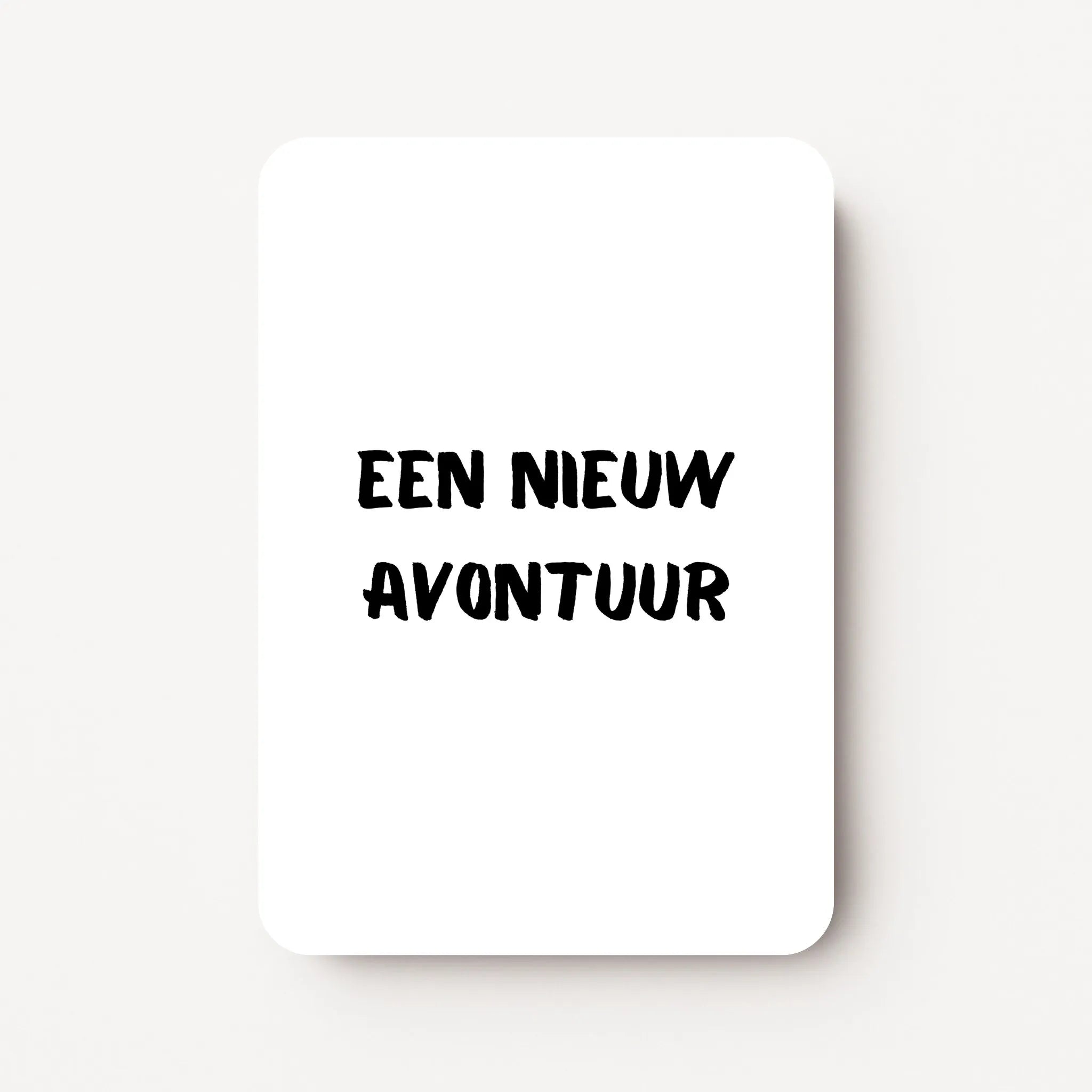 Staand minikaartje met zwarte tekst ‘Een nieuw avontuur’, minimalistisch ontwerp op witte achtergrond, flatlay op witte ondergrond.