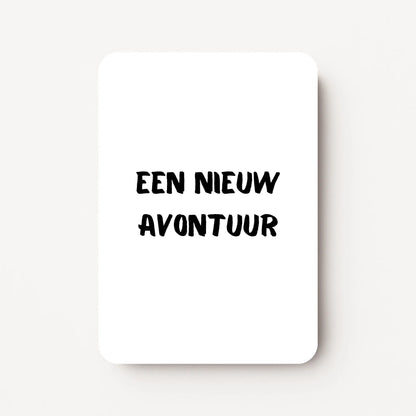Staand minikaartje met zwarte tekst ‘Een nieuw avontuur’, minimalistisch ontwerp op witte achtergrond, flatlay op witte ondergrond.