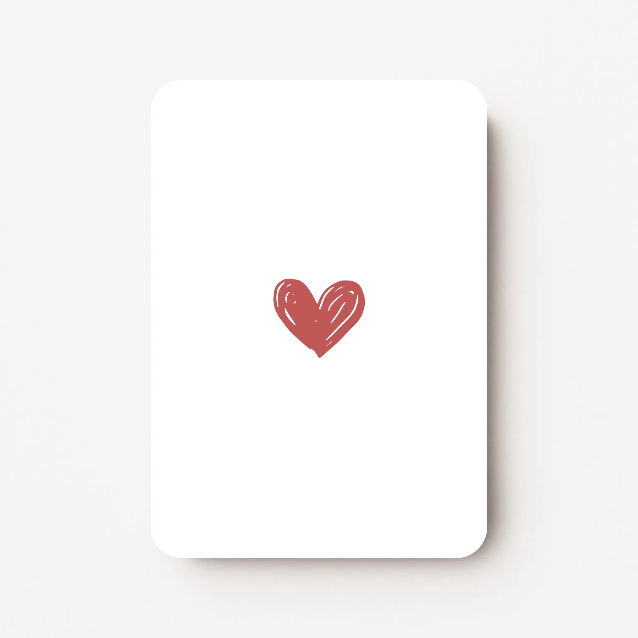 Staand minikaartje met een enkel hartje in warm roodroze kleur, minimalistisch ontwerp op witte achtergrond, flatlay op witte ondergrond.