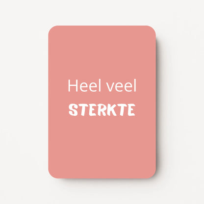 Staand minikaartje met witte tekst ‘Heel veel STERKTE’, minimalistisch ontwerp op een zachte roze achtergrond, flatlay op witte ondergrond.