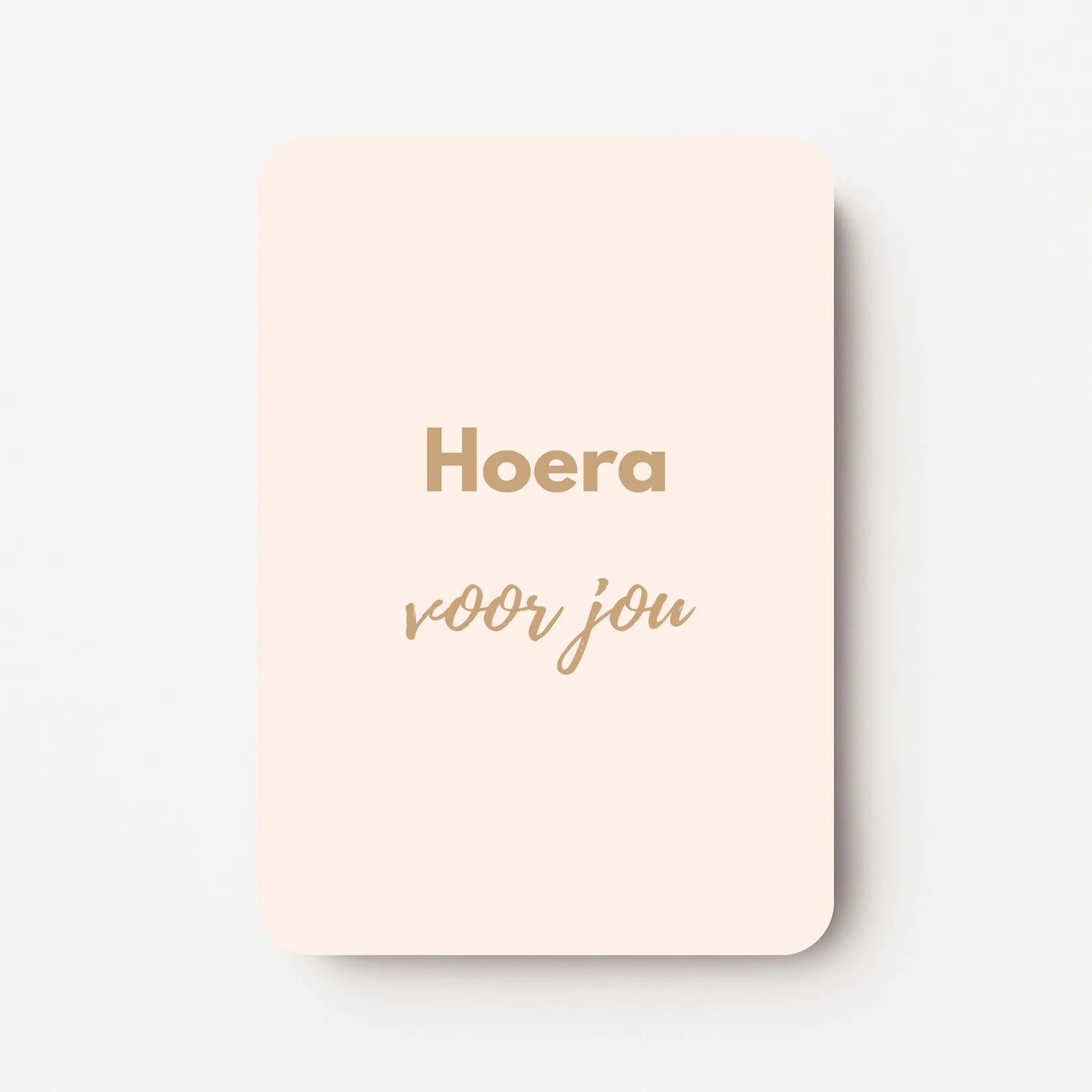 Staand minikaartje met goudbeige tekst ‘Hoera voor jou’, minimalistisch ontwerp op zachte roomkleurige achtergrond, flatlay op witte ondergrond.