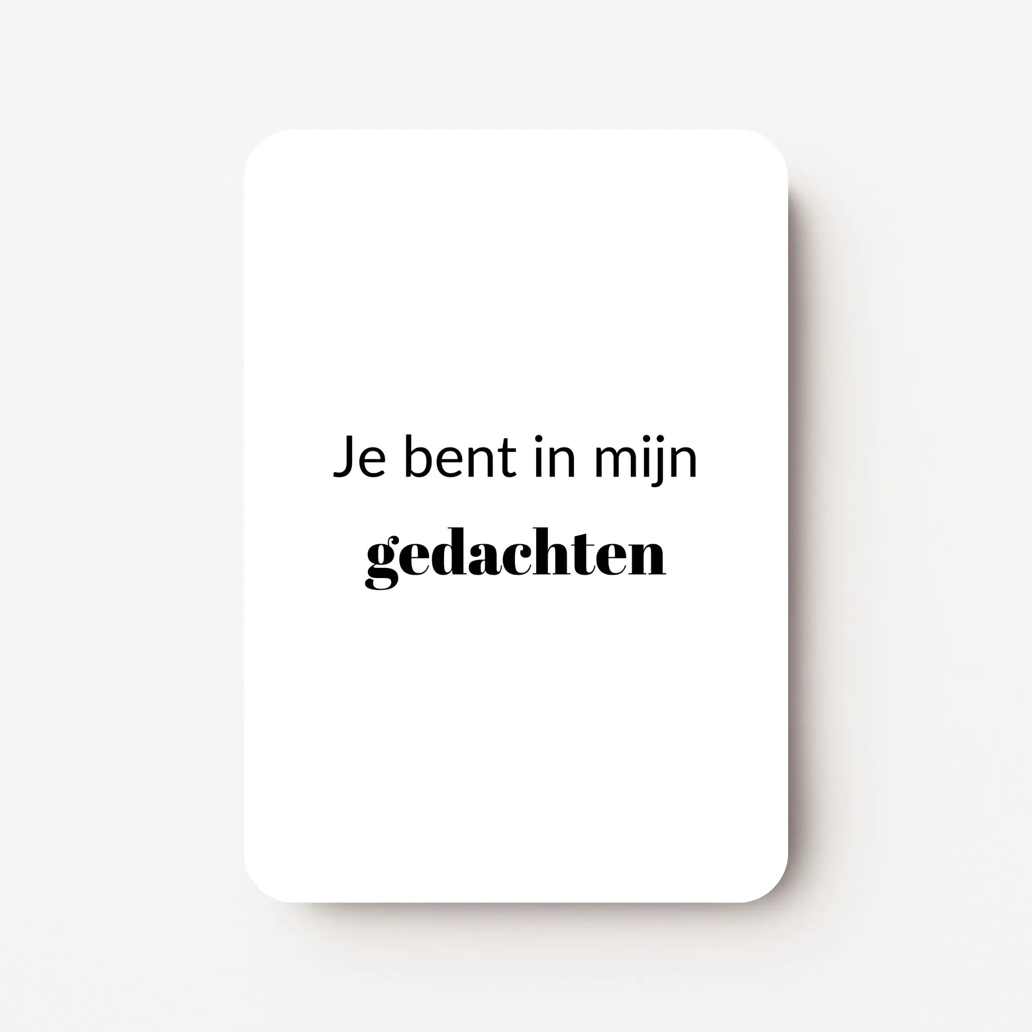 Staand minikaartje met zwarte tekst ‘Je bent in mijn gedachten’, minimalistisch ontwerp op witte achtergrond, flatlay op witte ondergrond.