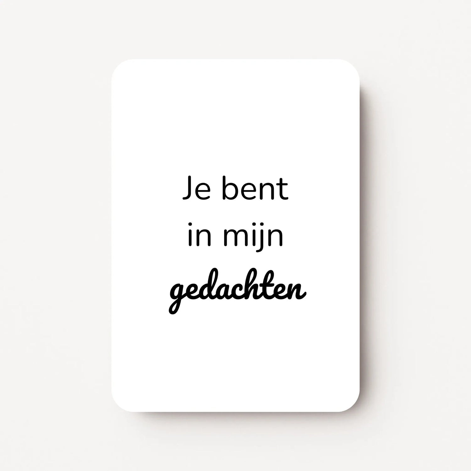 Staand minikaartje met tekst ‘Je bent in mijn gedachten’ in zwarte letters, minimalistisch ontwerp op witte achtergrond, flatlay op witte ondergrond.