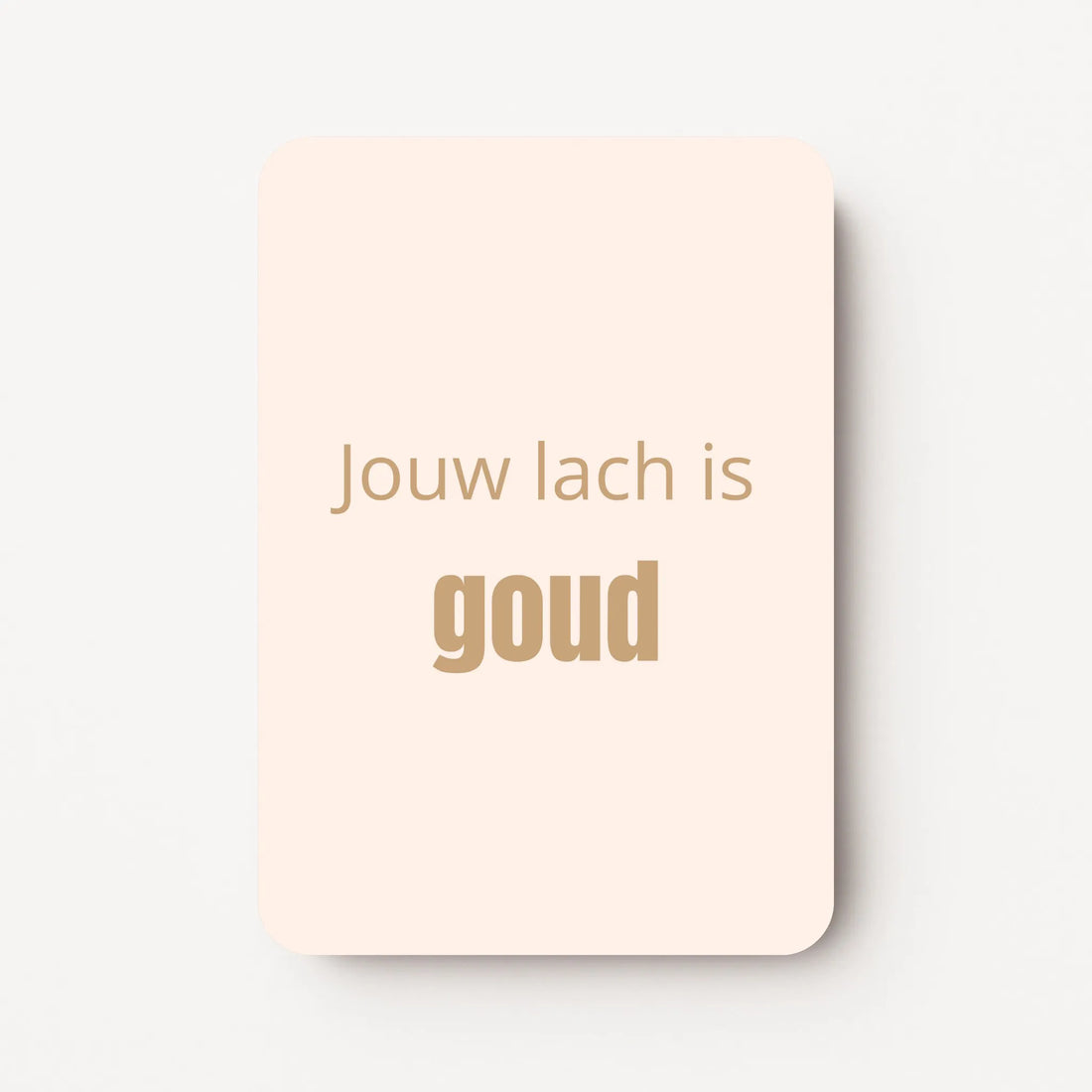 Staand minikaartje met goudbeige tekst ‘Jouw lach is GOUD’, minimalistisch ontwerp op een zachte perzik-witte achtergrond, flatlay op witte ondergrond.