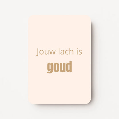 Staand minikaartje met goudbeige tekst ‘Jouw lach is GOUD’, minimalistisch ontwerp op een zachte perzik-witte achtergrond, flatlay op witte ondergrond.
