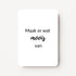 Staand minikaartje met zwarte tekst ‘Maak er wat moois van’, minimalistisch ontwerp op witte achtergrond, flatlay op witte ondergrond.