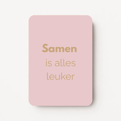 Staand minikaartje met goudbeige tekst ‘Samen is alles leuker’, minimalistisch ontwerp op een zachte lichtgrijze achtergrond, flatlay op witte ondergrond.