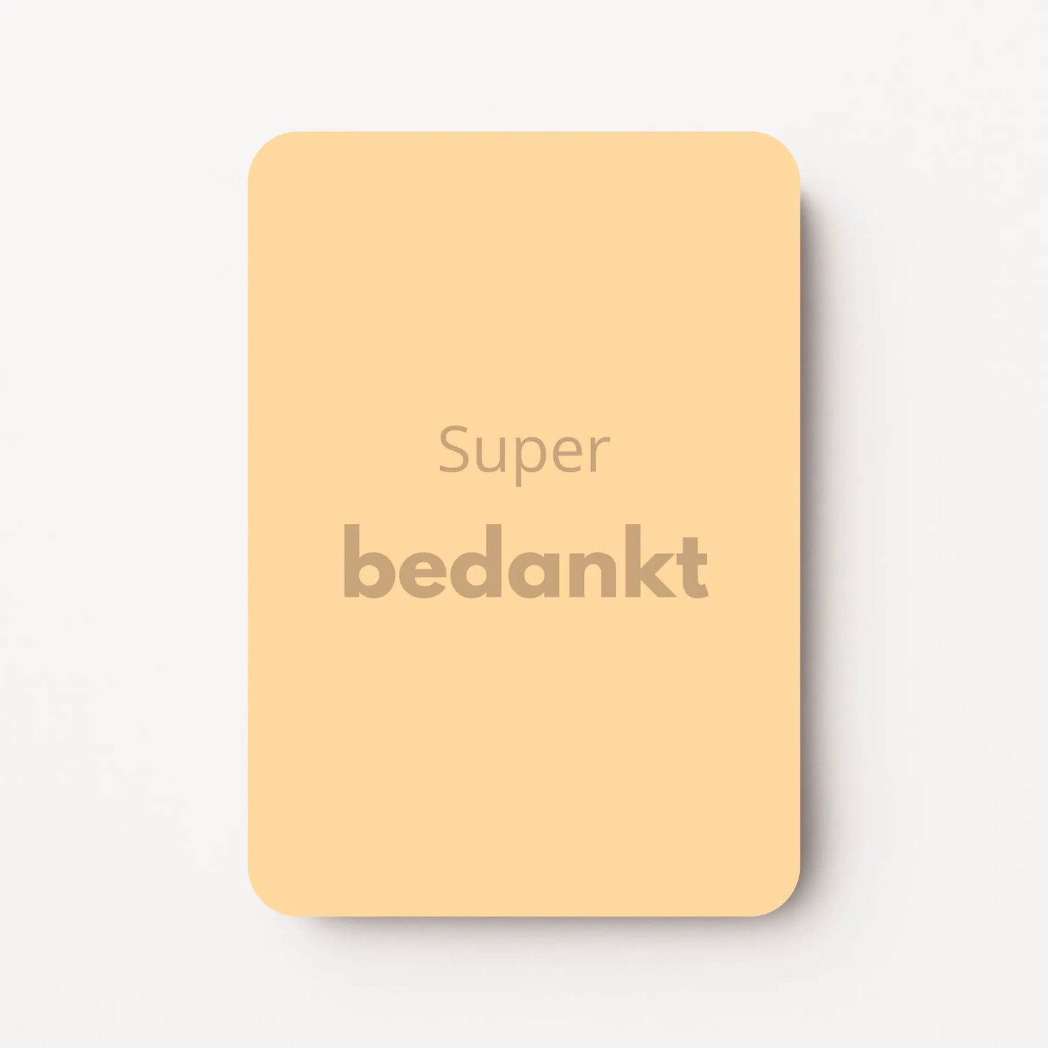 Staand minikaartje met tekst ‘Super bedankt’ in goudbeige letters, minimalistisch ontwerp op zachte abrikoos-gele achtergrond, flatlay op witte ondergrond.