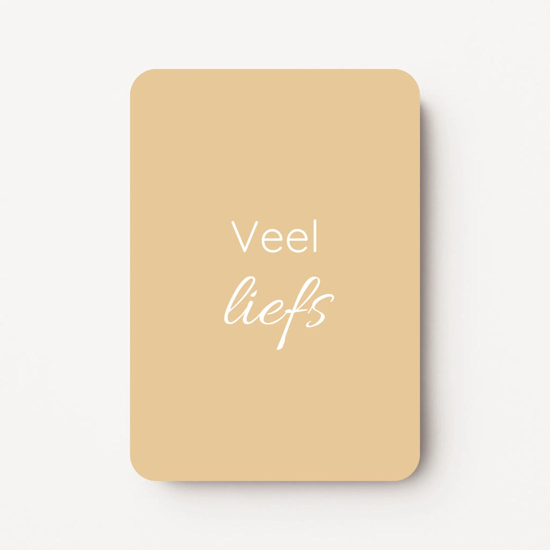 Staand minikaartje met tekst ‘Veel liefs’ in witte letters, minimalistisch ontwerp op zachte honinggele achtergrond, flatlay op witte ondergrond.