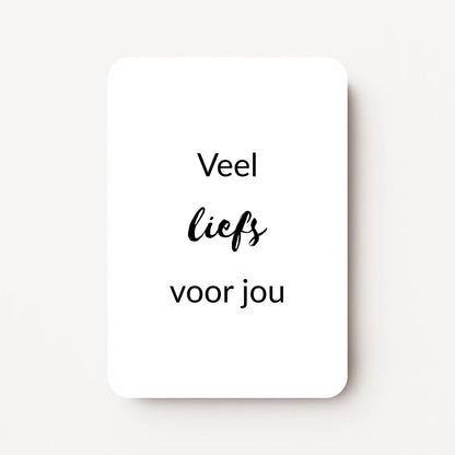 Staand minikaartje met zwarte tekst ‘Veel liefs voor jou’, minimalistisch ontwerp op witte achtergrond, flatlay op witte ondergrond.